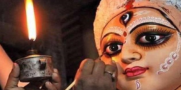 Hindu deity maker working in the night using a small oil lamp (Kolkata, Durga Puja).